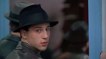 Movie still from “A Bronx Tale” (1993), directed by Robert De Niro – A young man wearing a black hat and a leather jacket; Close Up shot, Over the shoulder angle