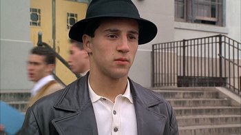 Movie still from “A Bronx Tale” (1993), directed by Robert De Niro – A young man wearing a black hat and a leather jacket; Close Up shot, Low angle