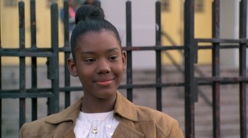 Movie still from “A Bronx Tale” (1993), directed by Robert De Niro – A young girl is standing in front of an iron fence; Close Up shot, Low angle