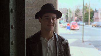 Movie still from “A Bronx Tale” (1993), directed by Robert De Niro – A young man wearing a hat and a leather jacket; Medium shot, Over the shoulder angle