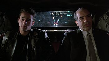Movie still from “A Bronx Tale” (1993), directed by Robert De Niro – Two men sitting in the back seat of a car at night; Medium shot, Low angle