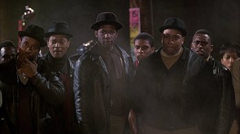 Movie still from “A Bronx Tale” (1993), directed by Robert De Niro – A group of men standing next to each other wearing hats; Medium shot, Low angle
