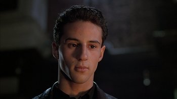 Movie still from “A Bronx Tale” (1993), directed by Robert De Niro – A young man in a black shirt is looking at the camera; Close Up shot, Low angle