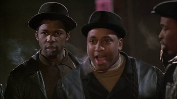 Movie still from “A Bronx Tale” (1993), directed by Robert De Niro – A couple of men standing next to each other; Close Up shot, Low angle