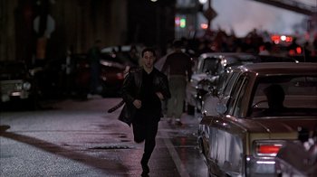 Movie still from “A Bronx Tale” (1993), directed by Robert De Niro – A man running down the street at night; Wide shot, High angle