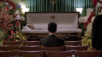 Movie still from “A Bronx Tale” (1993), directed by Robert De Niro – A man sitting in front of a casket in a church; Wide shot, High angle