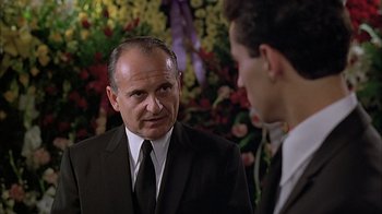 Movie still from “A Bronx Tale” (1993), directed by Robert De Niro – A man wearing a suit and tie talking to another man; Close Up shot, Over the shoulder angle