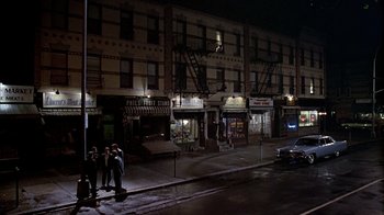 Movie still from “A Bronx Tale” (1993), directed by Robert De Niro – A group of people standing on the side of a road; Extreme Wide shot, High angle