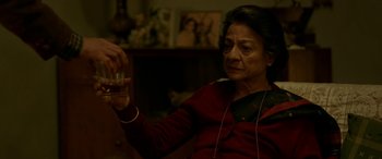 Movie still from “A Death in the Gunj” (2016), directed by Konkona Sen Sharma – An older woman is holding a glass of wine; Medium shot, High angle
