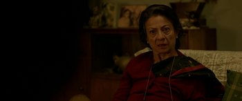 Movie still from “A Death in the Gunj” (2016), directed by Konkona Sen Sharma – An older woman wearing a red shirt and headphones; Close Up shot, High angle