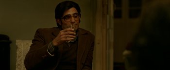 Movie still from “A Death in the Gunj” (2016), directed by Konkona Sen Sharma – A man in a brown jacket drinking a glass of water; Medium shot, Low angle