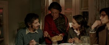 Movie still from “A Death in the Gunj” (2016), directed by Konkona Sen Sharma – Three people sitting at a table with a bowl of food in front of them; Medium shot, High angle