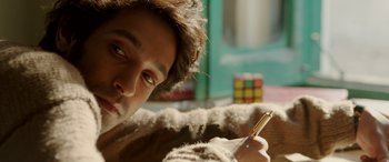 Movie still from “A Death in the Gunj” (2016), directed by Konkona Sen Sharma – A young man writing on a piece of paper; Close Up shot, Over the shoulder angle