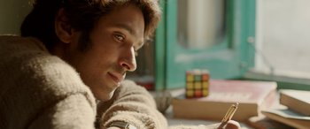 Movie still from “A Death in the Gunj” (2016), directed by Konkona Sen Sharma – A person with a rubiks cube in the background; Close Up shot, Over the shoulder angle