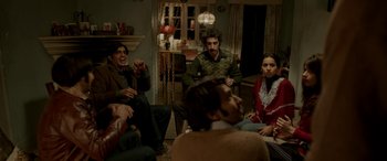 Movie still from “A Death in the Gunj” (2016), directed by Konkona Sen Sharma – A group of people sitting in a living room; Medium shot, High angle