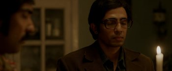 Movie still from “A Death in the Gunj” (2016), directed by Konkona Sen Sharma – A man in a brown suit and glasses looks to his left; Close Up shot, Over the shoulder angle