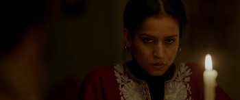 Movie still from “A Death in the Gunj” (2016), directed by Konkona Sen Sharma – A woman in a red and white jacket looking at the camera; Close Up shot, High angle