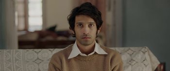 Movie still from “A Death in the Gunj” (2016), directed by Konkona Sen Sharma – A man in a brown sweater and a white shirt; Close Up shot, High angle