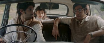 Movie still from “A Death in the Gunj” (2016), directed by Konkona Sen Sharma – Two men and a little girl sitting in the back of a car; Medium shot, Over the shoulder angle
