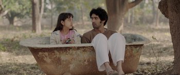 Movie still from “A Death in the Gunj” (2016), directed by Konkona Sen Sharma – A man and a little girl sitting next to each other; Medium shot, Over the shoulder angle