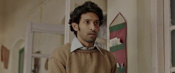 Movie still from “A Death in the Gunj” (2016), directed by Konkona Sen Sharma – A man in a brown sweater looking at the camera; Close Up shot, Low angle