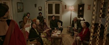 Movie still from “A Death in the Gunj” (2016), directed by Konkona Sen Sharma – A group of people sitting around a living room; Wide shot, High angle