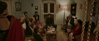 Movie still from “A Death in the Gunj” (2016), directed by Konkona Sen Sharma – A group of people sitting around a living room; Wide shot, High angle