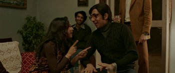 Movie still from “A Death in the Gunj” (2016), directed by Konkona Sen Sharma – A group of people sitting at a table talking to each other; Medium shot, Over the shoulder angle