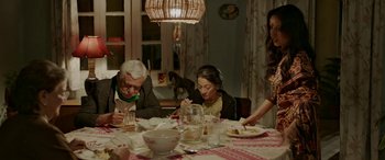 Movie still from “A Death in the Gunj” (2016), directed by Konkona Sen Sharma – A group of people sitting around a table eating food; Medium shot, High angle