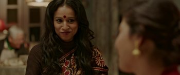 Movie still from “A Death in the Gunj” (2016), directed by Konkona Sen Sharma – A woman with long black hair wearing a red and brown dress; Close Up shot, Over the shoulder angle