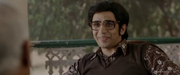 Movie still from “A Death in the Gunj” (2016), directed by Konkona Sen Sharma – A man wearing glasses and a brown vest; Close Up shot, Low angle