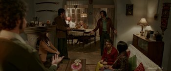 Movie still from “A Death in the Gunj” (2016), directed by Konkona Sen Sharma – A group of people sitting around a living room; Wide shot, High angle