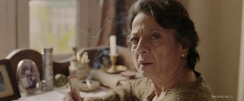 Movie still from “A Death in the Gunj” (2016), directed by Konkona Sen Sharma – An older woman sitting in front of a candle; Close Up shot, High angle
