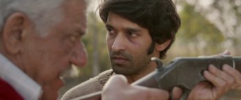 Movie still from “A Death in the Gunj” (2016), directed by Konkona Sen Sharma – A person holding a gun; Close Up shot, Over the shoulder angle