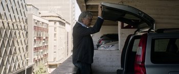 Movie still from “A Fantastic Woman” (2017), directed by Sebastián Lelio – An older man in a suit and tie holding onto a boat; Wide shot, Low angle