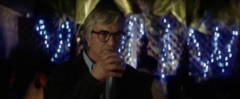 Movie still from “A Fantastic Woman” (2017), directed by Sebastián Lelio – A man with glasses is drinking a glass of wine; Close Up shot, Over the shoulder angle