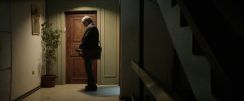 Movie still from “A Fantastic Woman” (2017), directed by Sebastián Lelio – An older man standing in front of a door; Wide shot, Low angle