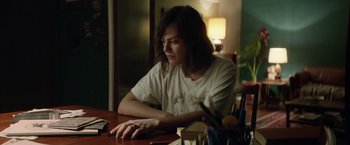 Movie still from “A Fantastic Woman” (2017), directed by Sebastián Lelio – A woman sitting at a table in front of a lamp; Medium shot, High angle