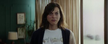 Movie still from “A Fantastic Woman” (2017), directed by Sebastián Lelio – A woman with long brown hair wearing a white t - shirt; Close Up shot, Low angle