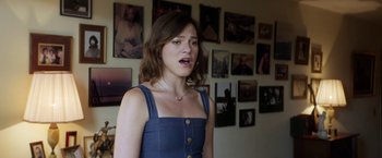 Movie still from “A Fantastic Woman” (2017), directed by Sebastián Lelio – A woman standing in front of a bunch of pictures; Medium shot, Over the shoulder angle