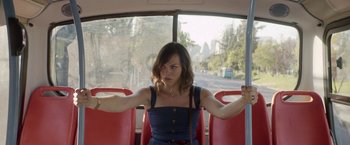 Movie still from “A Fantastic Woman” (2017), directed by Sebastián Lelio – A woman sitting on a bus with her arms crossed; Medium shot, Over the shoulder angle