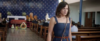 Movie still from “A Fantastic Woman” (2017), directed by Sebastián Lelio – A woman in a blue dress standing in front of people; Medium shot, Over the shoulder angle