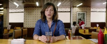 Movie still from “A Fantastic Woman” (2017), directed by Sebastián Lelio – A woman sitting at a table holding a glass of water; Close Up shot, High angle