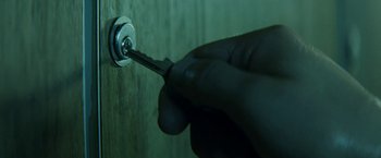 Movie still from “A Fantastic Woman” (2017), directed by Sebastián Lelio – A hand is holding a key to a key hole; Extreme Close Up shot, High angle