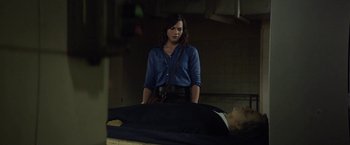 Movie still from “A Fantastic Woman” (2017), directed by Sebastián Lelio – A woman standing next to a man laying on a bed; Medium shot, Over the shoulder angle