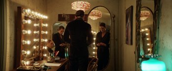 Movie still from “A Fantastic Woman” (2017), directed by Sebastián Lelio – A woman standing in front of a mirror looking at her phone; Medium shot, Over the shoulder angle