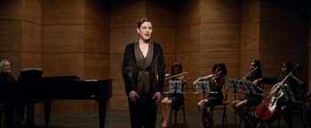 Movie still from “A Fantastic Woman” (2017), directed by Sebastián Lelio – A woman standing in front of a group of people; Medium shot, Over the shoulder angle