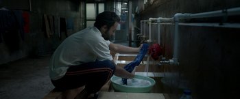 Movie still from “A Hero” (2021), directed by Asghar Farhadi – A man is washing his hands in a sink; Medium shot, Low angle