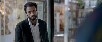Movie still from “A Hero” (2021), directed by Asghar Farhadi – A man with a beard wearing a suit; Close Up shot, Low angle