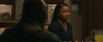 Movie still from “A Journal for Jordan” (2021), directed by Denzel Washington – A woman sitting in front of a man at a dinner table; Medium shot, Over the shoulder angle